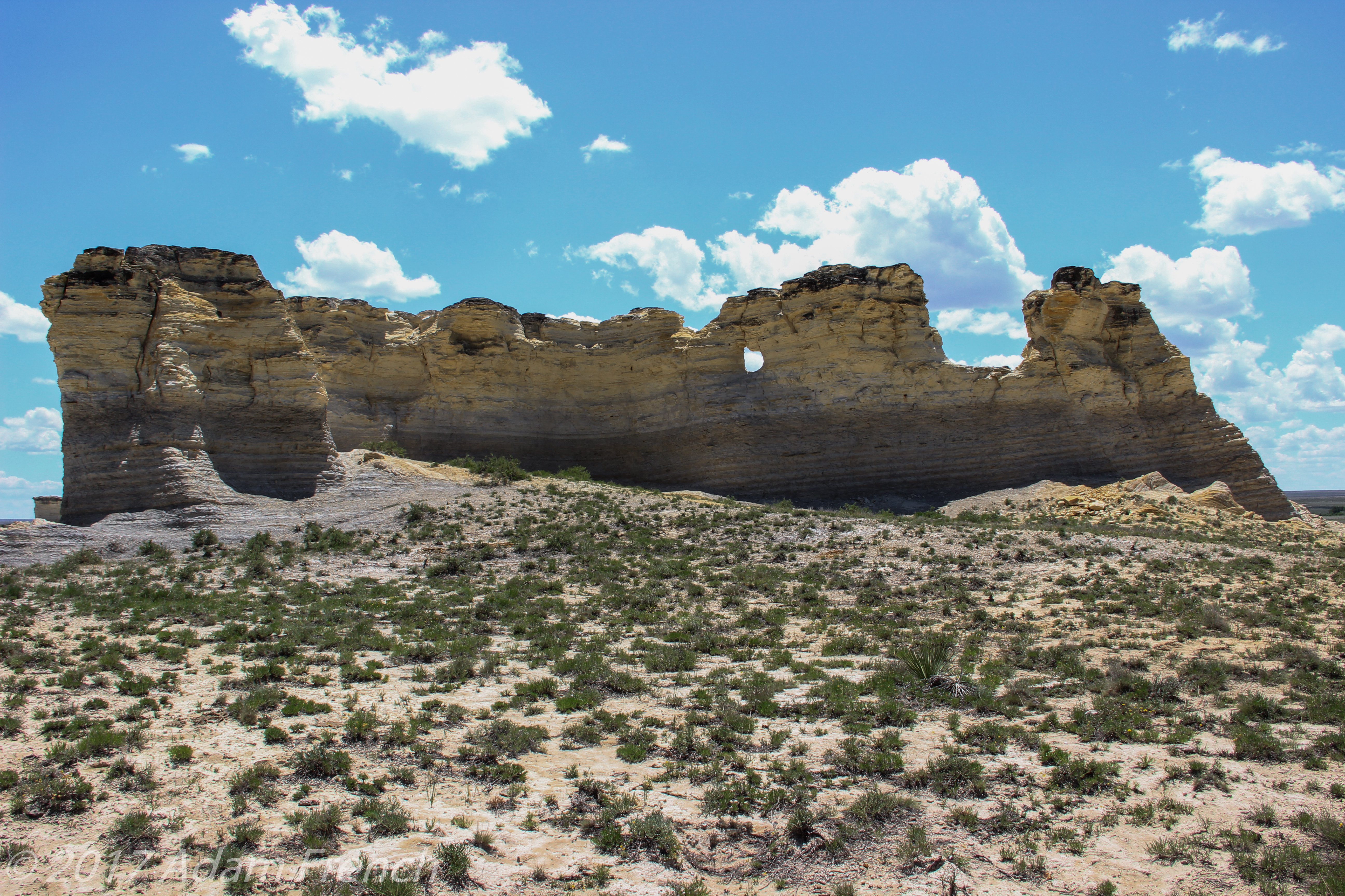 White, rock spires rise from the ground in sandy, desert-like scrubland