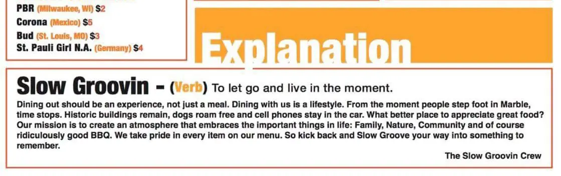 A blown-up image of the bottom of the Slow Groovin menu. At the bottom it reads, "Slow Groovin - (Verb) To let go and live in the moment. Dining out should be an experience, not just a meal. Dining with us is a lifestyle. From the moment people step foot in Marble, time stops. Historic buildings remain, dogs roam free and cell phones stay in the car. What better place to appreciate great food? Our mission is to create an atmosphere that embraces the important things in life: Family, Nature, Community and of course ridiculously good BBQ. We take pride in every item on our menu. So kick back and Slow Groove your way into something to remember. --The Slow Groovin Crew"