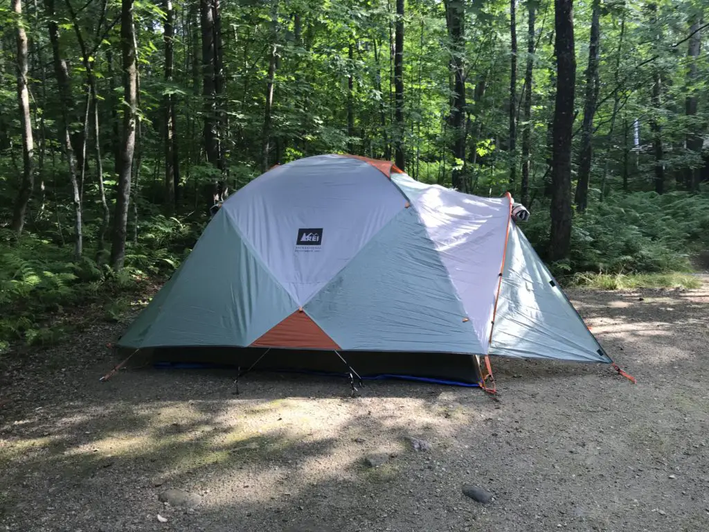 A tent sits on a wooded campsite