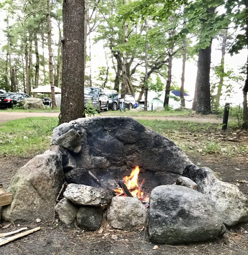 A small fire in a rocky hearth in a campground