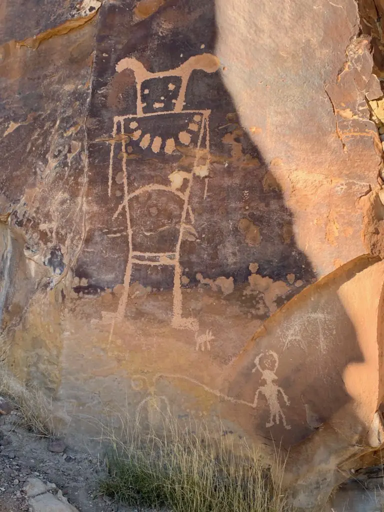 A sandstone, rock wall with an etching of a large figure