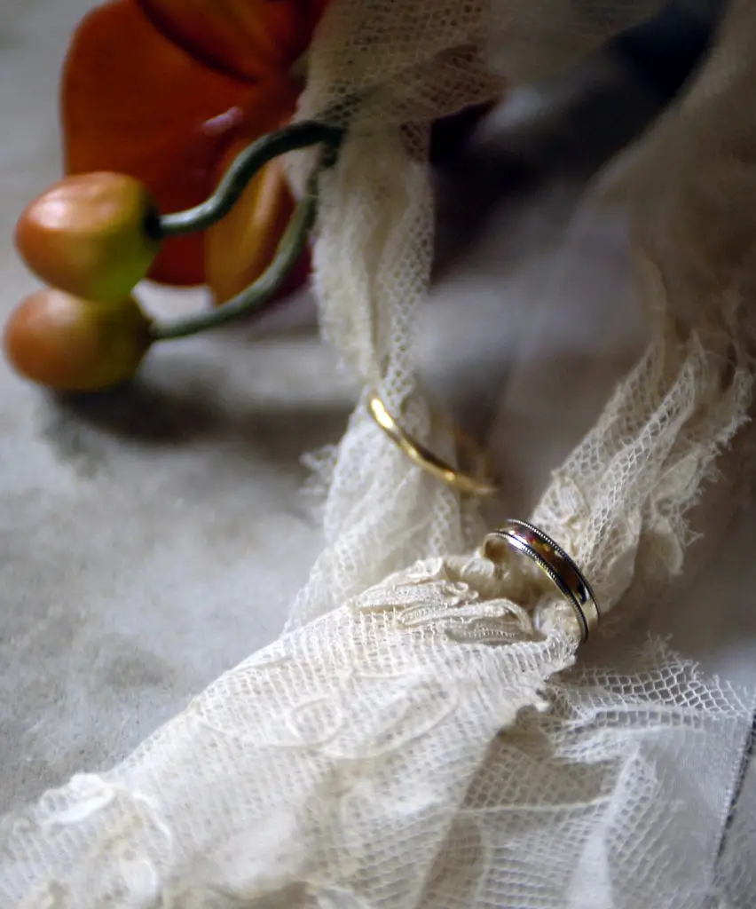 Two, old wedding rings with lace running through them