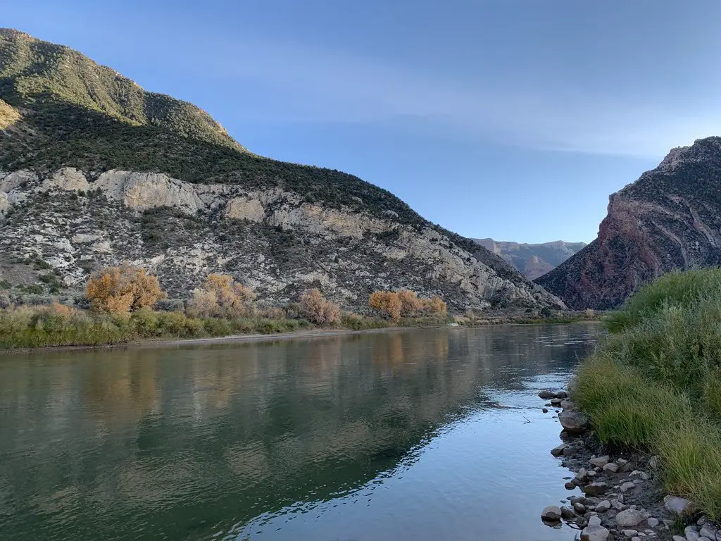 Calm creek runs through scrubbrush-covered canyon walls on both sides