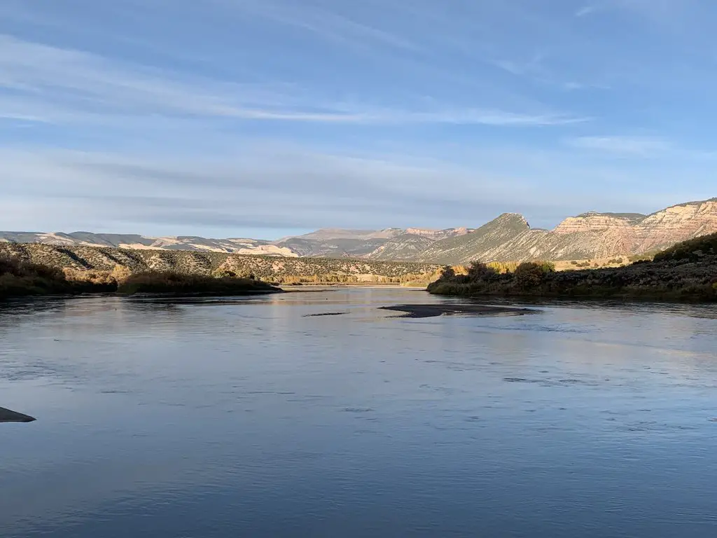 Lake with trees and rock mountains surrounding it and in the background