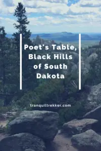 A mountain landscape with trees and rocks in the foreground. A meadow and more mountains are in the background. Pin reads, "Poet's Table, Black Hills of South Dakota"