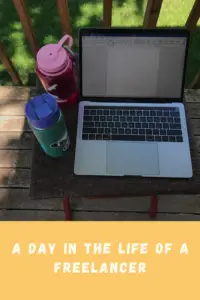 A laptop, water bottle and drink container sit on a table on the deck of a house. Pin reads, "A day in the life of a freelancer"