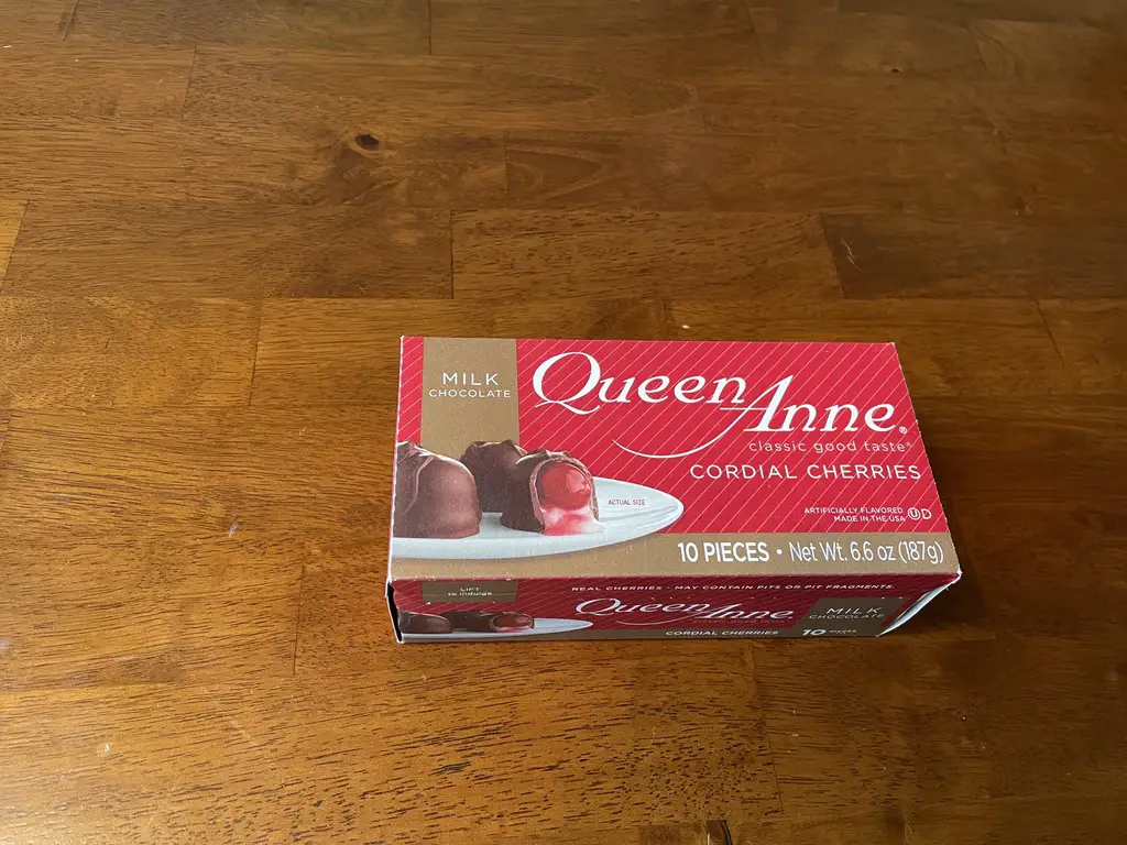 A box of Queen Anne cordial cherries sits on a table