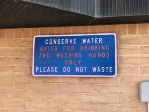 Sign that reads, "Conserve water. Water for drinking and washing hands only. Please do not waste."