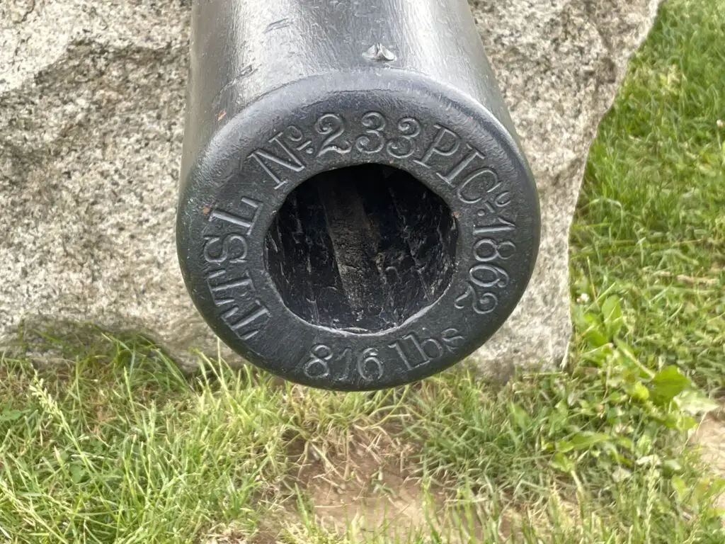 The front of a cannon with random numbers and letters stamped on it