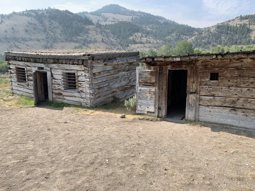 Old, wooden jails. Dusty mountains in background.