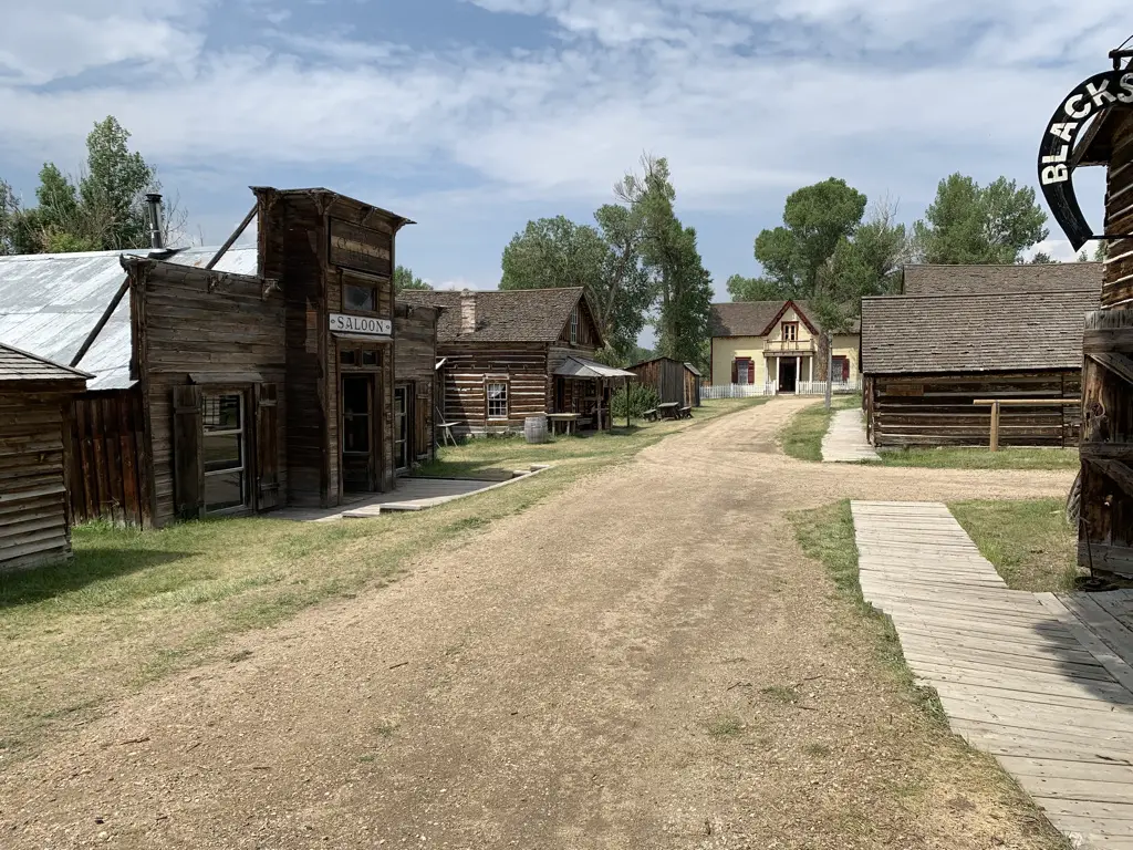 View down dirt, main street of Nevada City ghost town. Old, wooden buildings on each side.