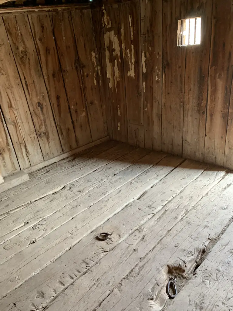 Interior of old, wooden jail. Shackle points in floor.