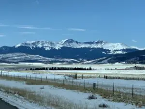 Snowy pastures with snow-covered Rocky Mountains in background