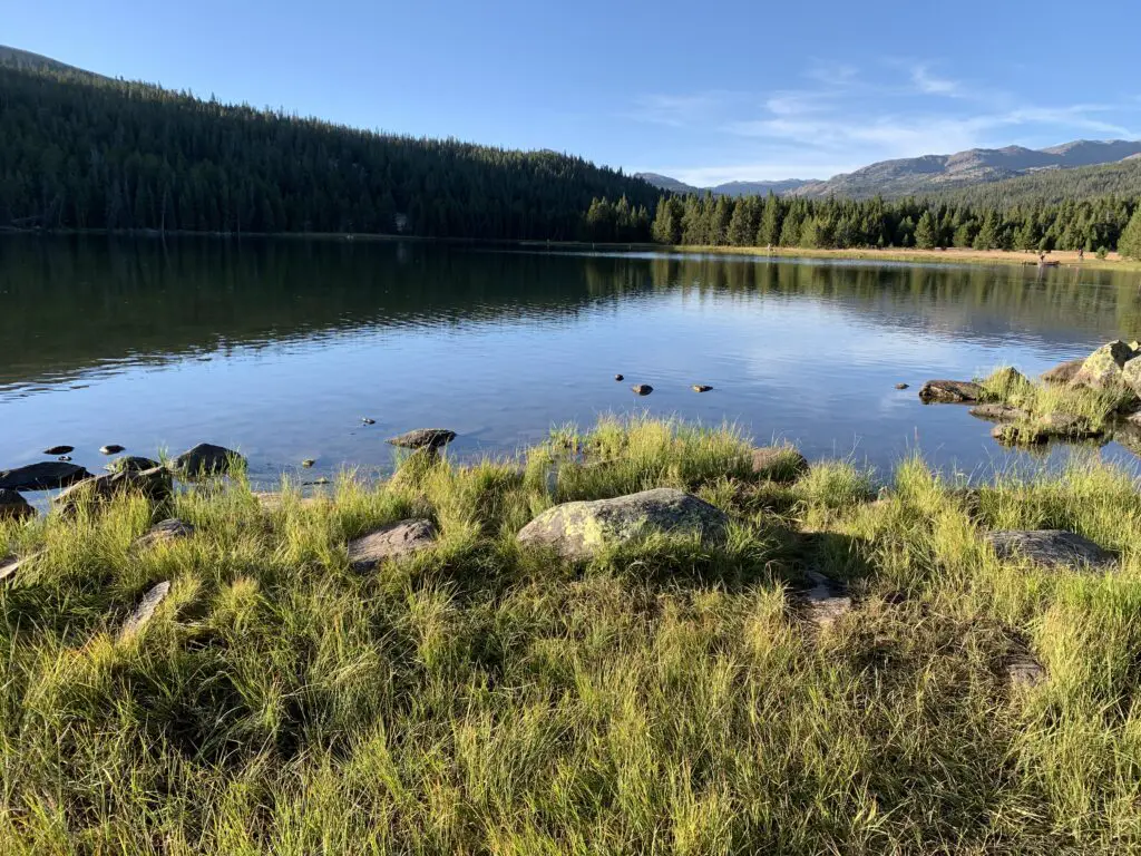 Serene lake reflecting the trees and mountains that surround it