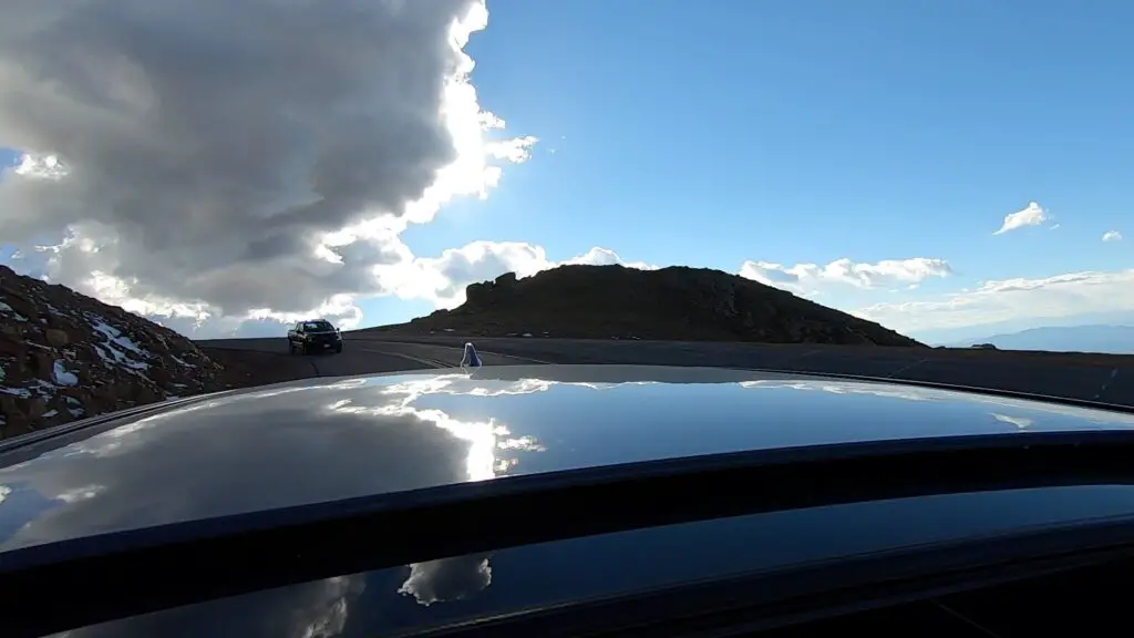 View from a car's sunroof looking behind the car at a police truck following behind. 