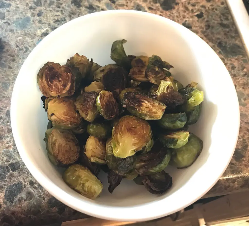 Browned brussel sprouts, cut up, in a bowl