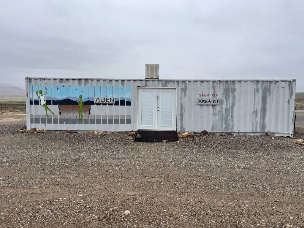 An old train car with a mural of aliens painted on the side