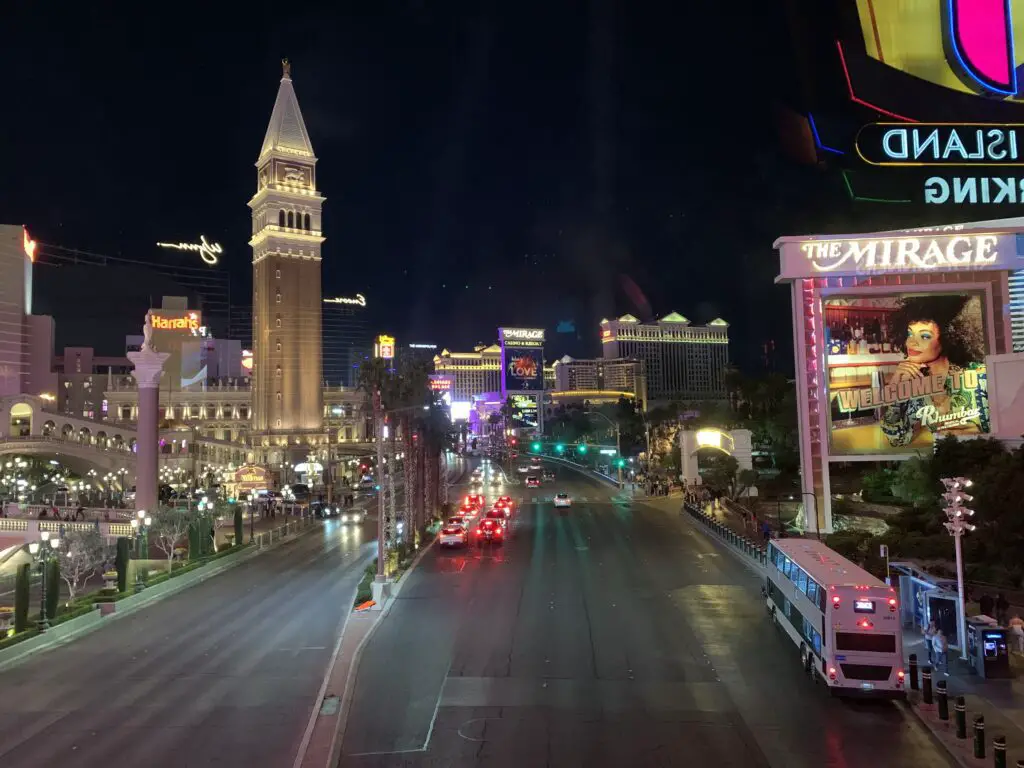 A large road surrounded by the lights of the Vegas Strip, at night
