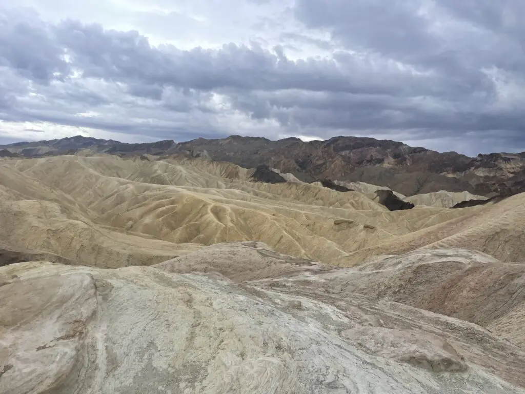 Yellow-grey dunes made of gravel sit under a grey, cloudy sky