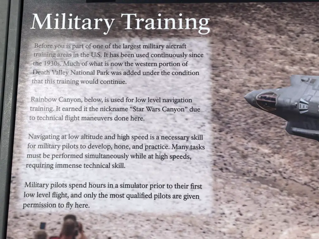 Info sign with a picture of a military jet flying above the canyon reads in part, "...Before you is a part of one of the largest, military aircraft training areas in the US...Rainbow Canyon, below, is used for low-level navigation training. It earned the nickname, 'Star Wars Canyon" due to technical flight maneuvers done here..."