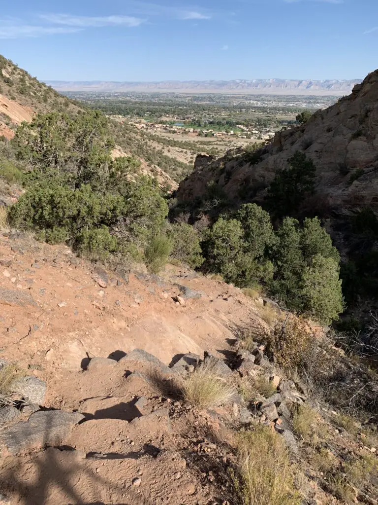 Stone and dirt steps carved into the side of a hill as it traverses the side of a steep canyon