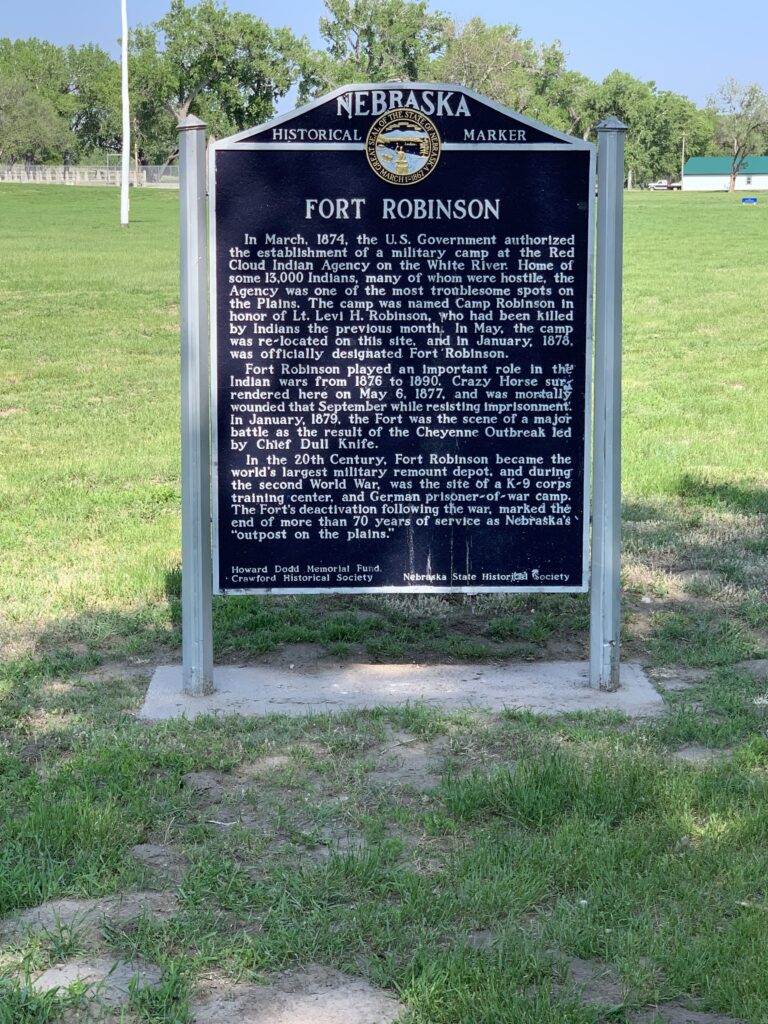 A historic sign reads, "Fort Robinson" and gives details about the fort